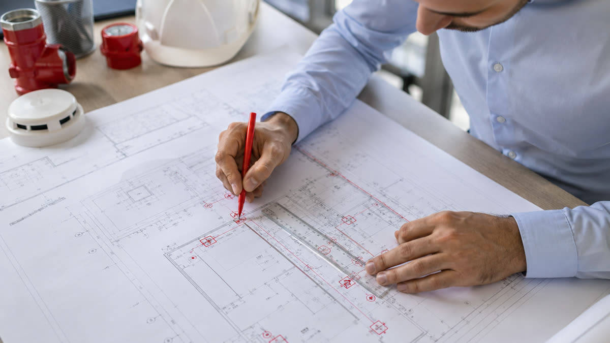 Engenheiro elaborando projeto PPCI com planta técnica de edificação em Santa Catarina