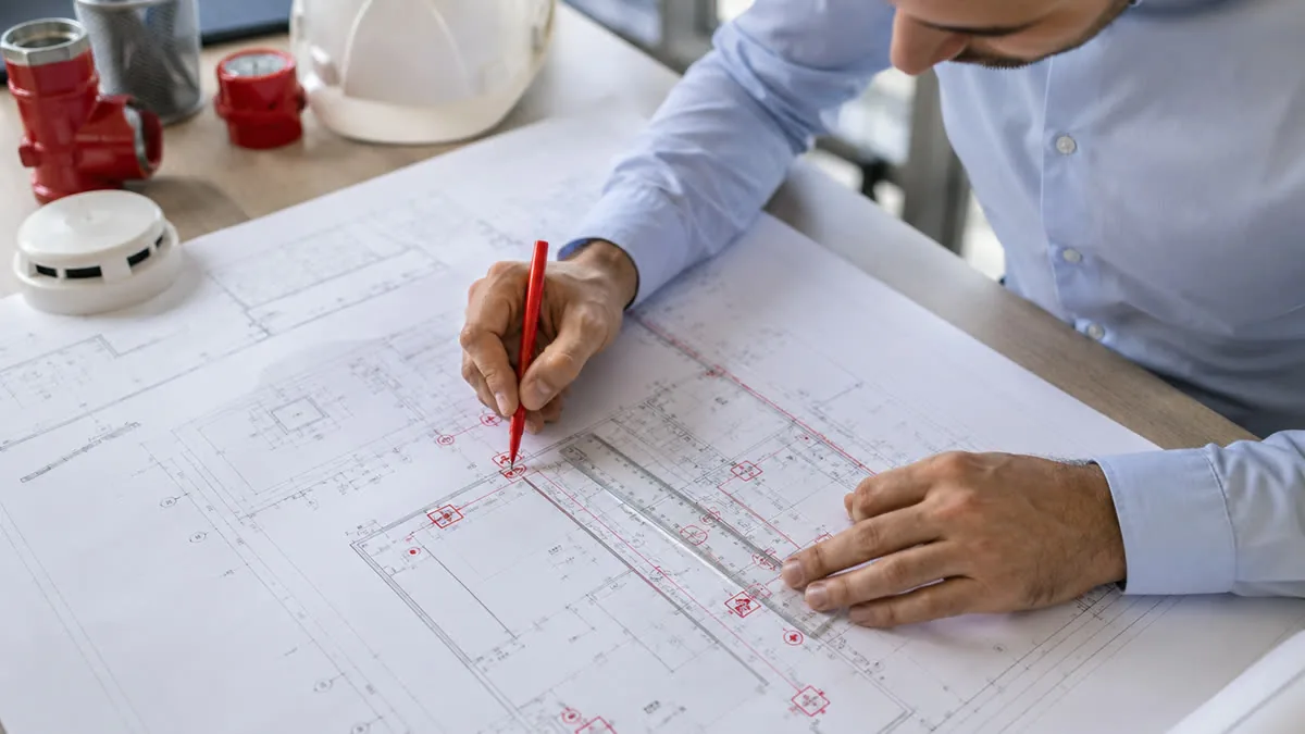Engenheiro elaborando projeto PPCI com planta técnica de edificação em Santa Catarina